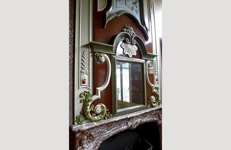 Verouderde spiegel in de typerend en zeer decoratieve 18e eeuwse schouw.
