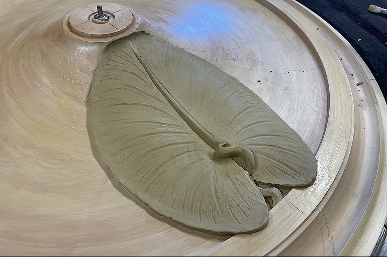 Handgemodelleerd waterlelieblad tijdens het maken van de Art Nouveau rozet